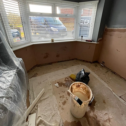 Mould removal underway in living room under a bay window.